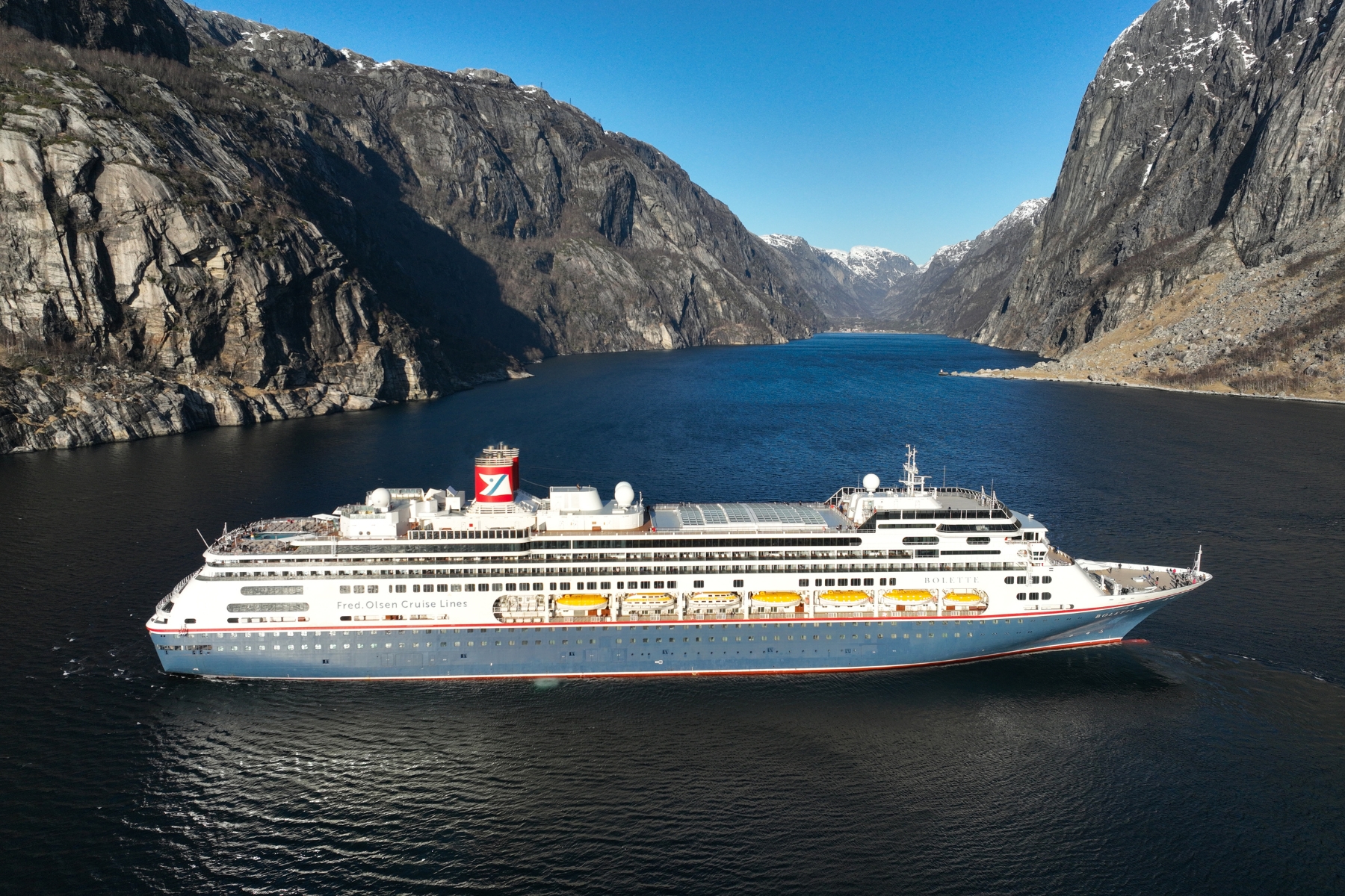 Fred. Olsen cruise ship cruising through dramatic fjords in Norway as part of a world cruise segment