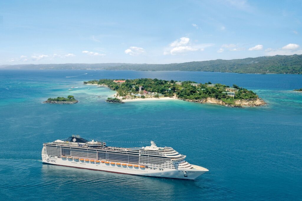 Cruise ship sailing on clear ocean waters during a world cruise segment